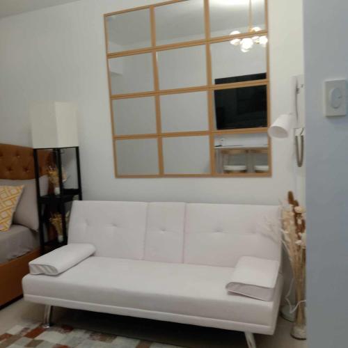- un canapé blanc dans le salon avec un miroir dans l'établissement GK's Condotel, à Manille