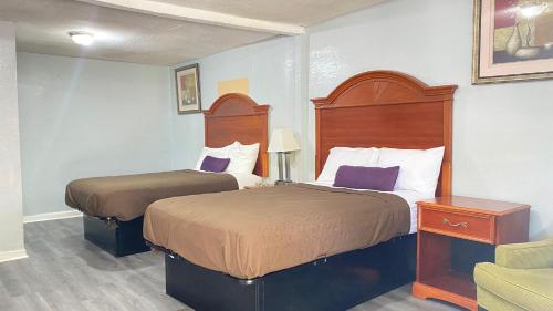 una habitación de hotel con 2 camas y una silla en Budget Inn Express en South Hill