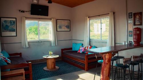 a room with a table and a couch and windows at Famiglia da Serra in Delfinópolis