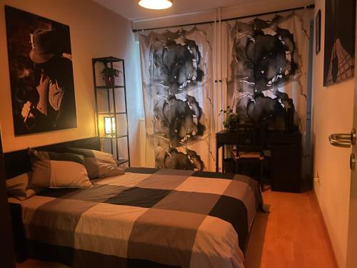 ein Schlafzimmer mit einem Bett mit einer schwarzen und weißen Decke in der Unterkunft Alt Treptow Fashion HQ in Berlin