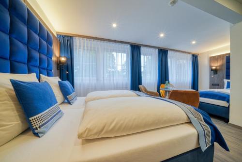 a bedroom with two beds and a blue headboard at Zentrum Hotel Stade in Stade