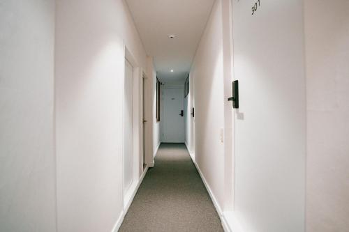 an empty hallway with white walls and a long corridor at Stay Ccassette Player in Mokpo