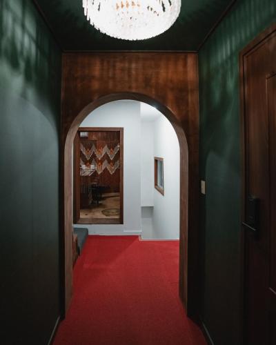 a hallway with a red carpet and a chandelier at Stay Ccassette Player in Mokpo