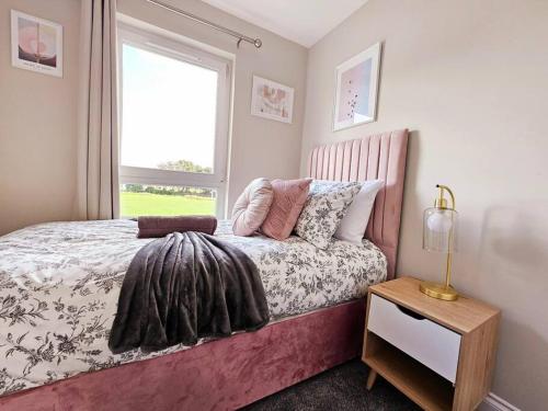 a bedroom with a bed with a window and a table at Modern 5 Bedroom Townhouse with Free Parking in Glasgow