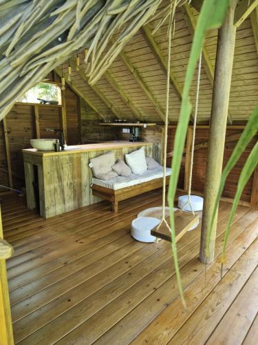 een kamer met een bed in een houten huis bij PURA VIDA Lodge Cabane perchée in Sainte-Rose