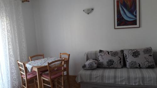 a room with a table and a couch and a table and chairs at Piadora in Banjol