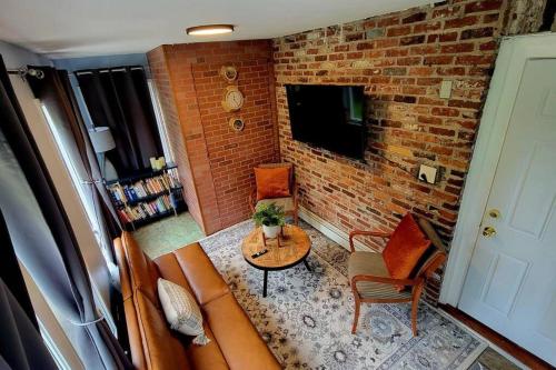 a living room with a couch and a brick wall at Unique & Peaceful Boston Home( Free Parking) in Boston