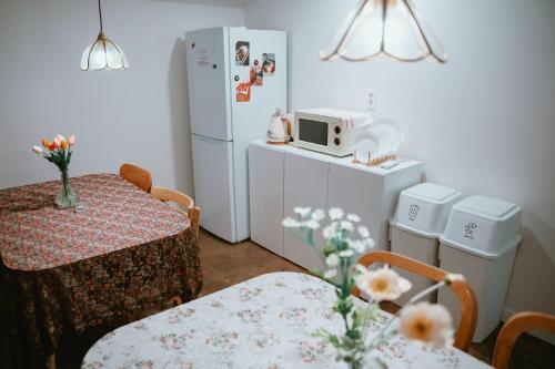 a small kitchen with a table and a white refrigerator at Stay Ccassette Player in Mokpo