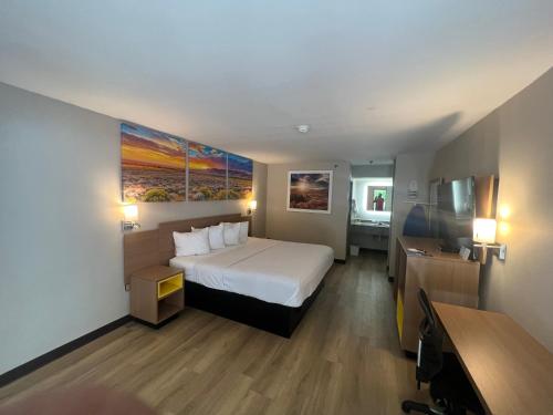 a hotel room with a bed and a painting on the wall at Days Inn by Wyndham Covington in Covington