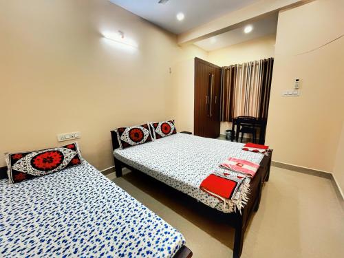 um quarto com duas camas e uma cadeira. em Thrissur Villas Home Stay em Thrissur