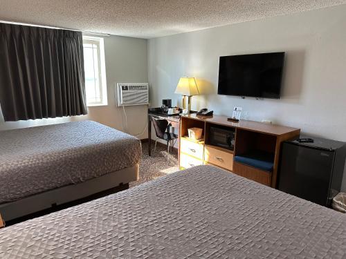 a hotel room with two beds and a flat screen tv at Yankton Inn in Yankton