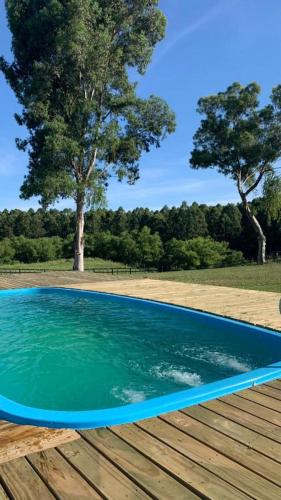 une piscine d'eau bleue sur une terrasse en bois dans l'établissement Cabaña Familiar en Complejo Los Tres Rubios, à Rivera