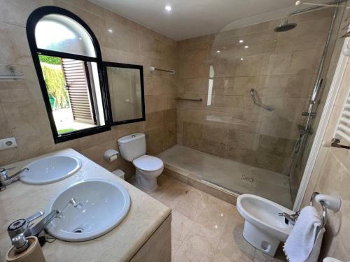 a bathroom with two sinks and a shower and a toilet at Casa de Playa in Estepona