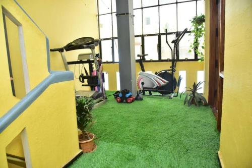a gym with treadmill and exercise equipment in a room at Citylight Family Homestay in Mysore