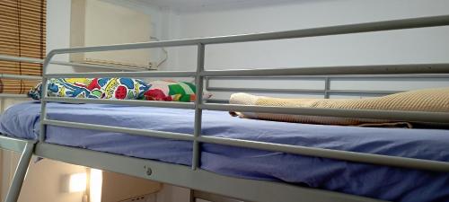 a bunk bed with blue sheets and pillows on it at Habitación Albergue en Parque Natural in Sant Pere de Reixac