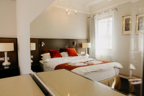a hotel room with a bed with red pillows at Excelsior INN in Turda