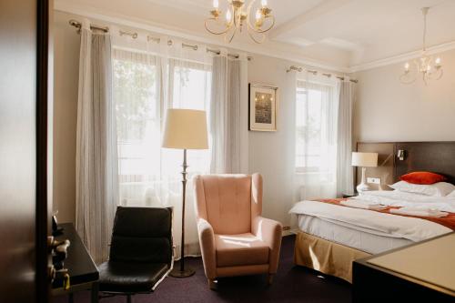 a bedroom with a bed and a chair at Excelsior INN in Turda