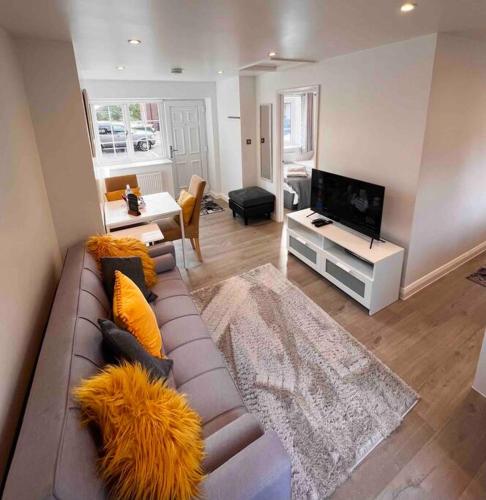 a living room with a couch and a tv at Minster Hilltop Apartment in Minster