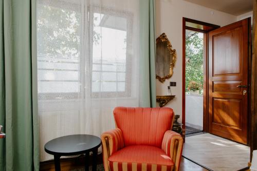 an orange chair in a room with a window at Excelsior INN in Turda