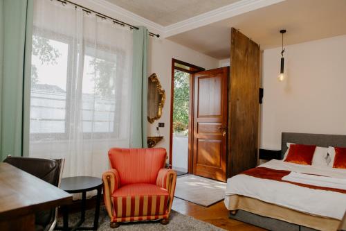 a bedroom with a bed and a chair and a table at Excelsior INN in Turda