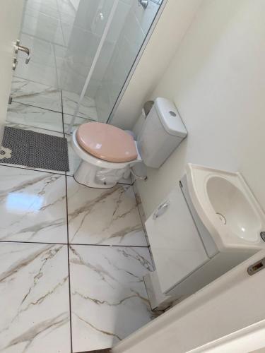 La salle de bains blanche est pourvue de toilettes et d'un lavabo. dans l'établissement Apart. Bela Vista, à Porto Ferreira