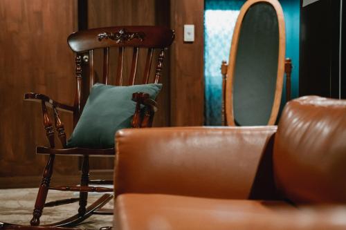 a wooden rocking chair with a green pillow on it at Stay Ccassette Player in Mokpo