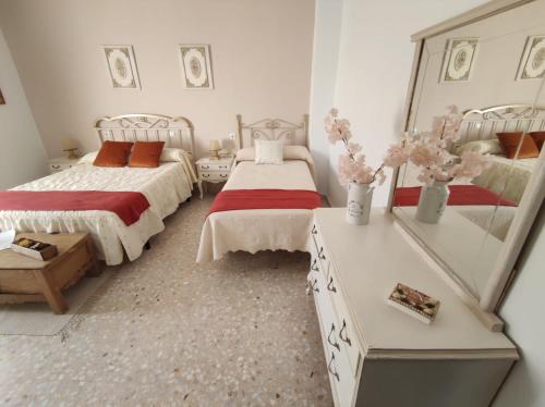 1 dormitorio con 2 camas y espejo en Alojamiento Rural Casa la Abuela, en Arbuniel