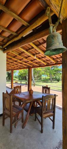 einen Holztisch und Stühle unter einem Holzdach in der Unterkunft Canto do Moreira Corumbau in Corumbau