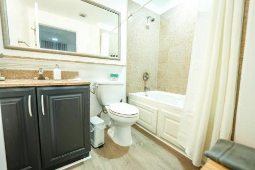 a bathroom with a toilet and a sink and a bath tub at Apartment 5 min away from Disney 1st Floor in Orlando