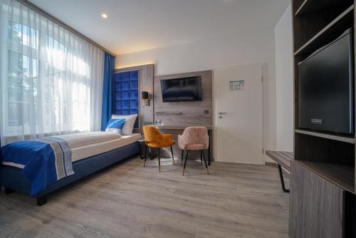 a bedroom with a bed and a flat screen tv at Zentrum Hotel Stade in Stade