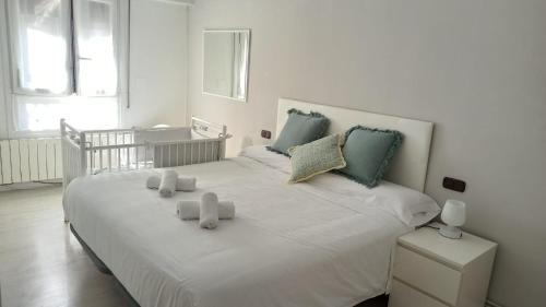ein Schlafzimmer mit einem großen weißen Bett mit zwei Kissen in der Unterkunft Ohana, Apartamento-CENTRICO-WIFI-ASCENSOR- PARKING PRIVADO GRATIS-SIN CUESTAS in Bermeo