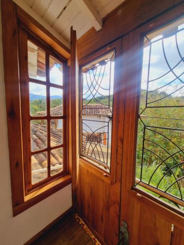 a room with two windows and a view of a mountain at Pousada Cipó Artes in Prados