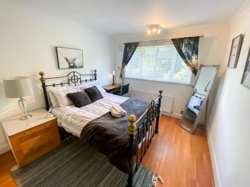 a bedroom with a large bed and a window at Stunning Modern Cozy 5 star 3 bedroom house-Free Parking Greater London Metro Stations hosted by Tony in Catford