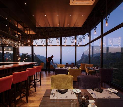 a restaurant with a view of the mountains with tables and chairs at HIDE ELLA Hotel & Resort in Ella
