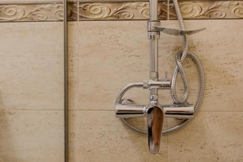 a shower head hanging on a wall at Excelsior INN in Turda