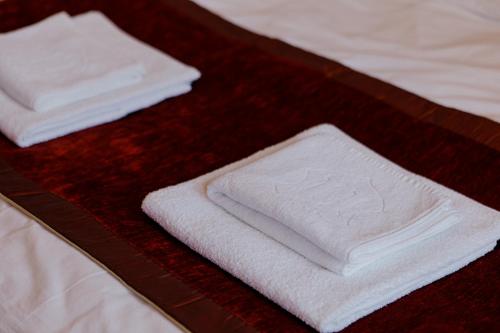 two white towels sitting on top of a bed at Excelsior INN in Turda