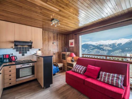 un canapé rouge dans une cuisine avec vue sur les montagnes dans l'établissement Studio cosy et fonctionnel à Courchevel, accès direct aux pistes - FR-1-563-67, à Courchevel