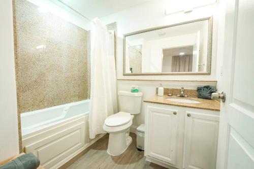 a bathroom with a toilet and a sink and a mirror at Apt Orlando 11th Floor 5 min from Disney in Orlando