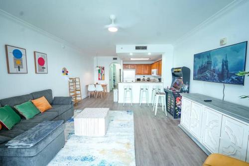 a living room with a couch and a kitchen at Apt Orlando 11th Floor 5 min from Disney in Orlando