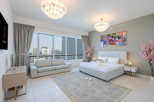 a living room with a white couch and a large window at Duplex Penthouse with Maid's Room - Dubai Marina - Livbnb in Dubai