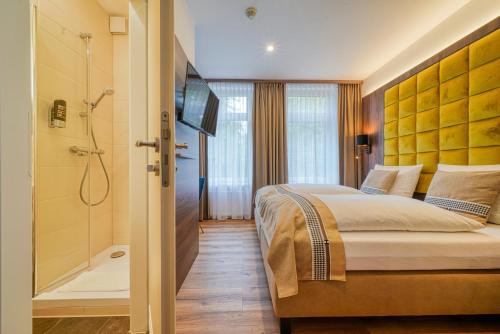 a hotel room with a bed and a shower at Zentrum Hotel Stade in Stade