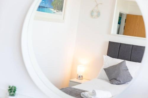 a bedroom with a white bed and a mirror at Newquay Sunset & Sea View Apartment in Town Centre in Newquay