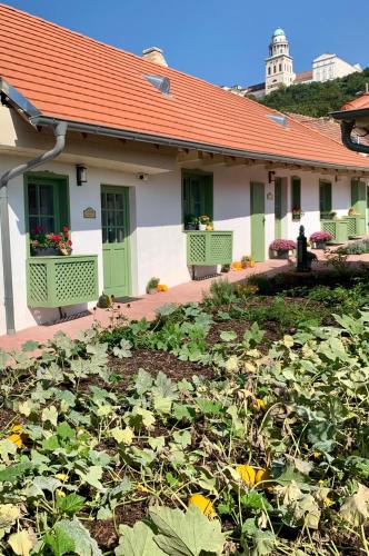a house with a lot of plants in the yard at Pannonhalma Várlak Vendégház in Pannonhalma