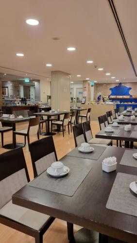 une salle à manger avec des tables et des chaises dans une cafétéria dans l'établissement Hotel Principe Lisboa, à Lisbonne