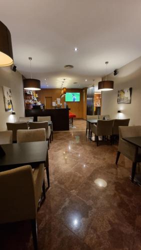 a restaurant with tables and chairs and a bar at Hotel Principe Lisboa in Lisbon