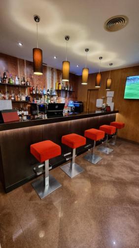 a bar with red stools in a restaurant at Hotel Principe Lisboa in Lisbon