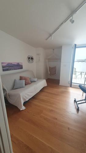 ein weißes Zimmer mit einem Bett und einem Stuhl darin in der Unterkunft EmmeGI Home di fronte alla Fiera di Foggia in Foggia