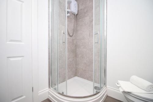 W łazience znajduje się prysznic ze szklanymi drzwiami. w obiekcie Casa di pietra - Cardiff City centre apartment with patio, Free private parking w Cardiff