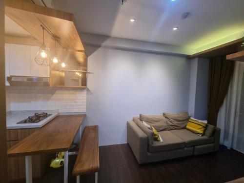 a living room with a couch and a kitchen at SIGNATURE PARK GRANDE MT.Haryono in Jakarta