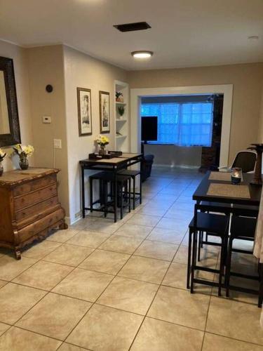 a living room with two tables and a television at Hidden Gem 3br/1b+Jacuzzi+busch garden+fishn+kayak in Tampa
